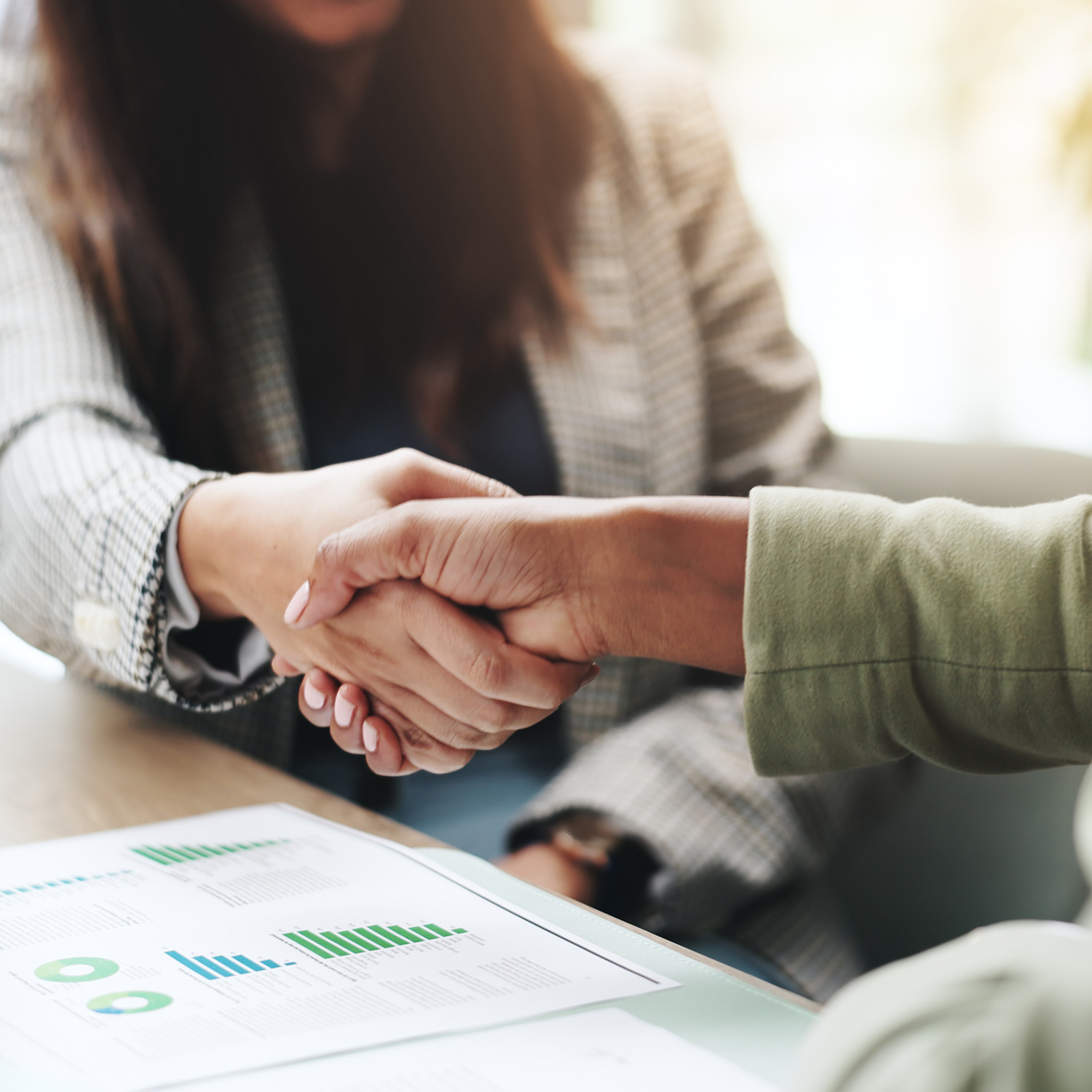 Hands, business people and handshake with deal, graphs and profit growth or sales analytics. Closeup, thank you and financial advisor with agreement, B2B welcome or CRM with charts or company revenue